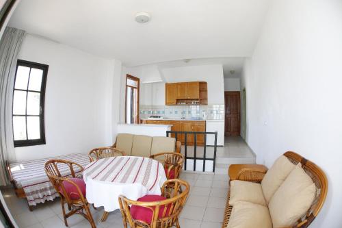 a living room with a table and chairs and a kitchen at Mer in Fethiye