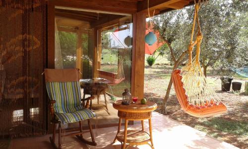 a porch with a hammock and a table and chairs at Chalet Mimosa in Itri