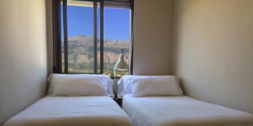 Dos camas en una habitación con una gran ventana. en Fornet_24, en Altea