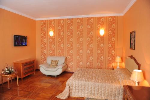 a bedroom with a bed and a chair at Gostinichny Komplex Germes in Karagandy
