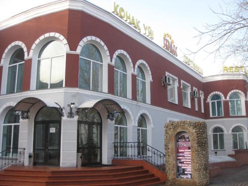 - un bâtiment rouge et blanc avec des escaliers devant dans l'établissement Gostinichny Komplex Germes, à Karaganda