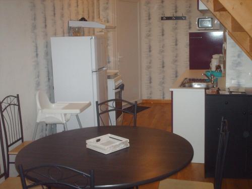a kitchen with a table and a refrigerator at Meublé de tourisme*** letrilogis in Joinville