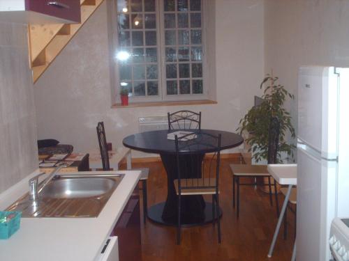 a kitchen with a black table and chairs and a sink at Meublé de tourisme*** letrilogis in Joinville