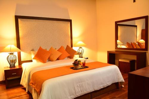 a bedroom with a large bed and two mirrors at Villa Mount Royal in Nuwara Eliya