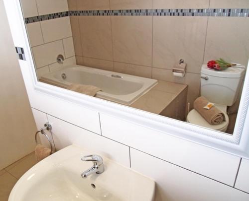 a bathroom with a tub and a toilet and a sink at Travel Lodge Sabie in Sabie