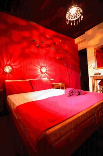 a red bedroom with a large bed with a red wall at Guesthouse Patavali in Kalabaka