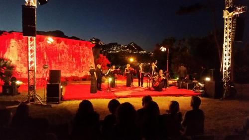 un grupo de personas en un escenario por la noche en Villa Verdemare Naxos, en Giardini Naxos