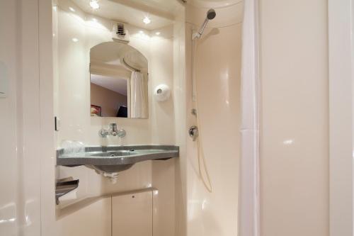 a bathroom with a sink and a shower at Premiere Classe Dunkerque Est Armbouts Cappel in Armbouts-Cappel