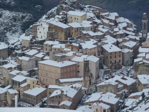 a town covered in snow on a mountain at A Spelunca in Speloncato