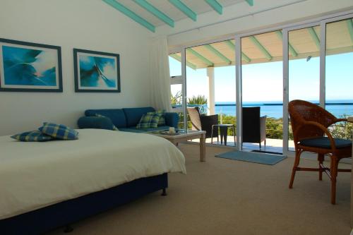a bedroom with a bed and a view of the ocean at Cintsa Lodge in Chintsa