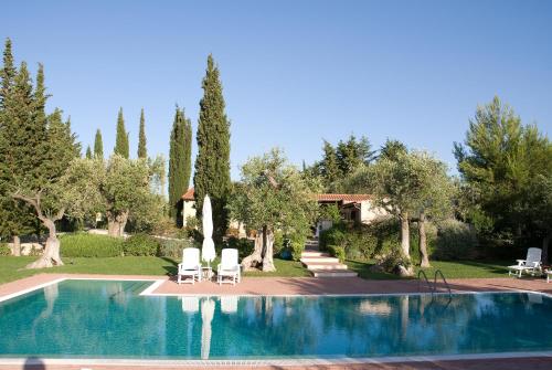 una piscina con due sedie a sdraio e alberi di Casa vacanze Leralora a Conversano