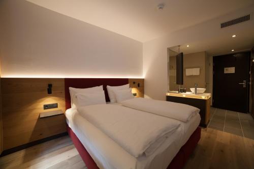 a hotel room with a large bed and a large window at Diamond City Hotel Tulln in Tulln