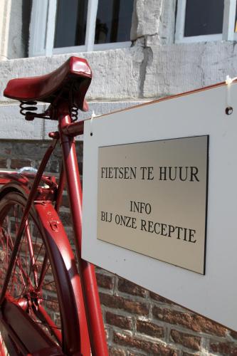 a sign on a red bike next to a building at Abdij Hotel Rolduc in Kerkrade