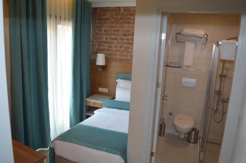アマスラにあるSardinia Otelのベッド1台とシャワー付きの小さな客室です。