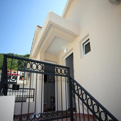 a white house with a balcony with a black railing at Apartments Raičević in Budva