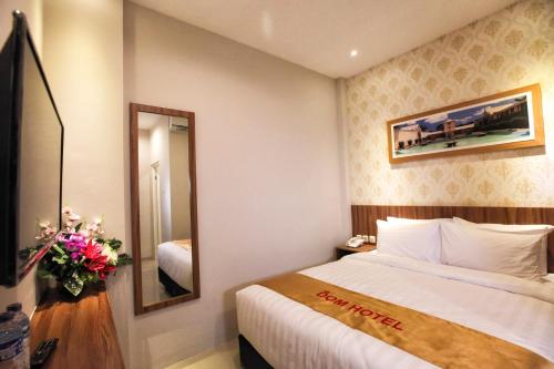 a hotel room with a bed and a mirror at DOM Hotel Jogja in Yogyakarta