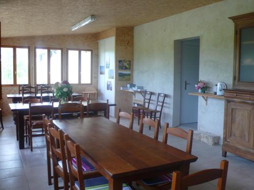 une salle à manger avec des tables et des chaises en bois dans l'établissement Alpagas du Quercy, à Frayssinet