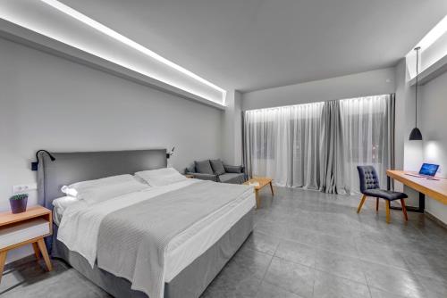 a bedroom with a large bed and a desk at Naves Suites in Ermoupoli