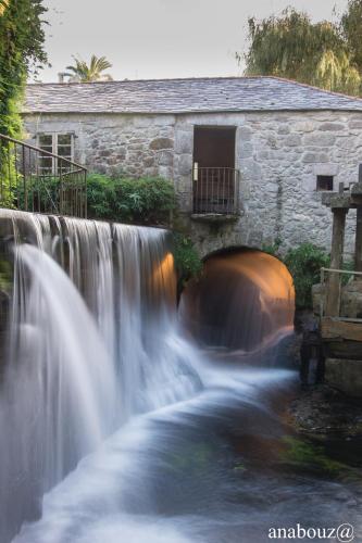 a waterfall in front of a stone building at Finca Galea in Carballido