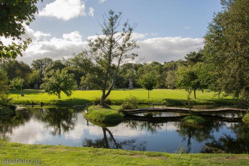 a pond in a park with a bridge and trees at Finca Galea in Carballido
