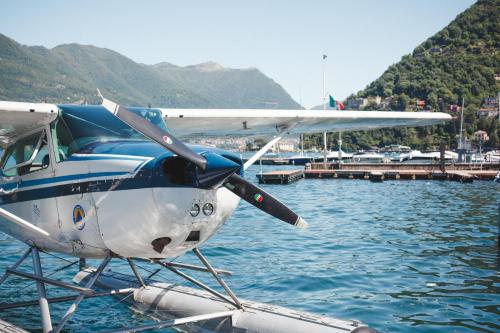 a small plane sitting in the water next to a dock at Alessia's Place in Como