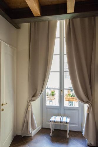 a window with curtains and a bench in front of it at Alessia's Place in Como