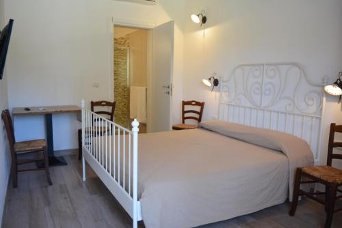ポルト・チェザーレオにあるAgriturismo "Terra D'Ulivi"のベッドルーム(白いベッド1台、椅子数脚付)