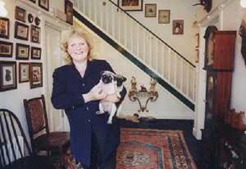 una mujer sosteniendo un perro en un pasillo en Milton House, en Edimburgo