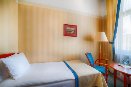 a hotel room with a bed and a table and chairs at Focus Hotel Premium Pod Orłem in Bydgoszcz