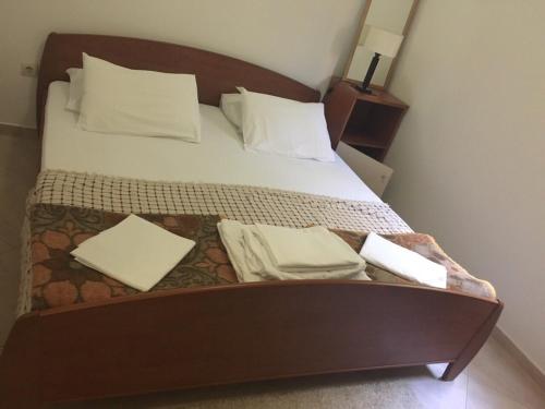 a bed with white sheets and pillows on it at Apartments Ivan in Petrovac na Moru