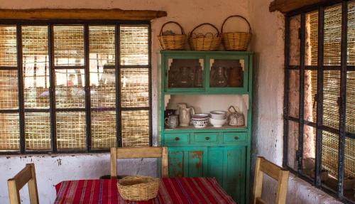 una cocina con un armario verde y una mesa con sillas en Chakana Hospedaje Rural en Villa Unión