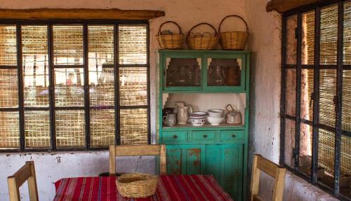 a kitchen with a green cabinet and a table with chairs at Chakana Hospedaje Rural in Villa Unión