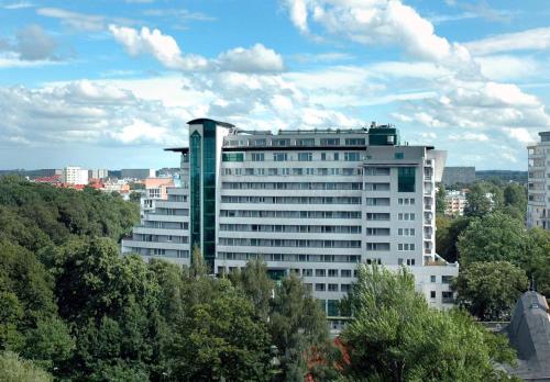 コウォブジェクにあるPoppy Apartment Kolobrzegの目の前に木々が植えられた白い大きな建物