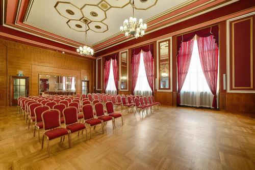 an empty room with red chairs and a chandelier at Focus Hotel Premium Pod Orłem in Bydgoszcz