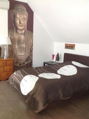1 dormitorio con 1 cama con una estatua en la pared en Serenity, en Le Landin