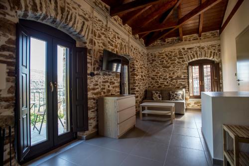 a kitchen with stone walls and a large window at Thalia Traditional Guest House in Promírion