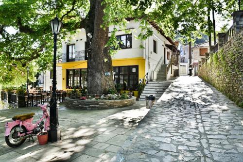 a pink bike parked next to a tree on a street at Thalia Traditional Guest House in Promírion