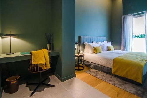a bedroom with a bed and a desk and a window at Bordoy Casa Ládico - Hotel Boutique Adults Only in Mahón