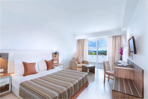 a hotel room with a bed and a chair at Club Shark Hotel in Gümbet