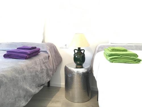 1 dormitorio con 1 cama y 1 mesa con lámpara en Mezquita Home, en Córdoba