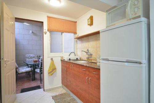 a kitchen with a white refrigerator and a table at Mali Country Hospitality in Eilat