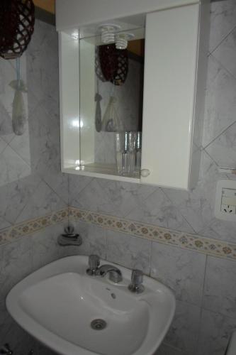 a bathroom sink with a mirror and a white cabinet at La Casona de Susana in Colón