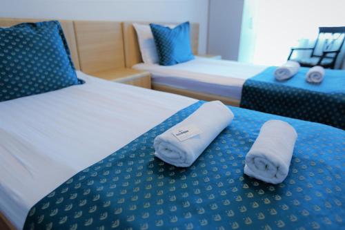 two towels on a bed in a hotel room at Hotel Pejton in Pristina