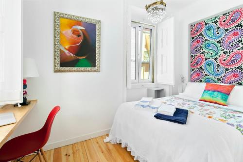 a white bedroom with a white bed and a red chair at FeelingLisbon Tejo in Lisbon