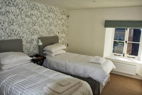 a hotel room with two beds and a window at Ivythorpe Coach House in Bath
