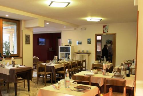 a restaurant with tables and chairs and a person in the doorway at Bar Trattoria Colombina Affittacamere in Bossico