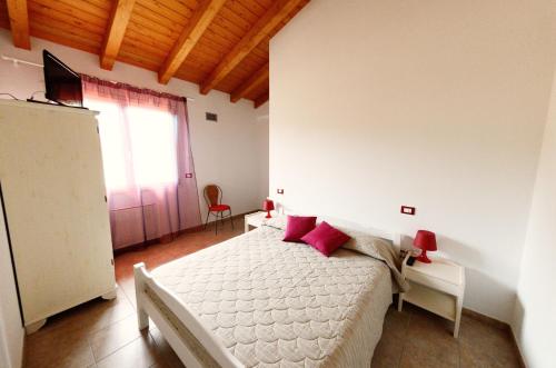 ein Schlafzimmer mit einem Bett mit roten Kissen darauf in der Unterkunft B&B Al Tardino in Sogliano al Rubicone