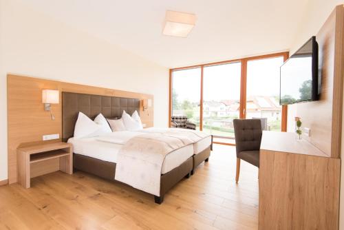 a bedroom with a large bed and a large window at Hotel-Restaurant Gruber in Pöllau