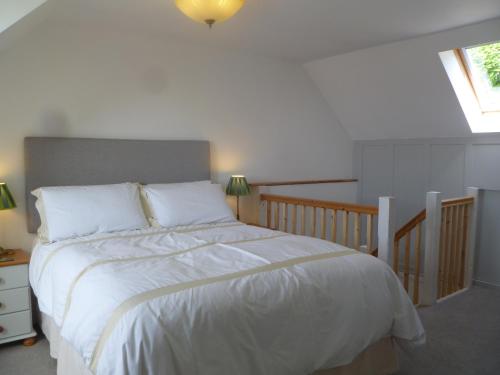 a bedroom with a bed with white sheets and a window at The Nook @ Drop Anchor in Portishead