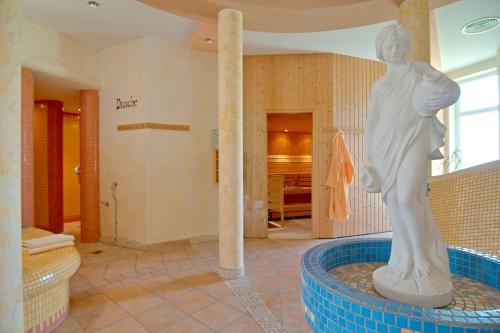 un bagno con statua nel mezzo di una vasca di Erlebnis-Hotel-Appartements a Latschach ober dem Faakersee
